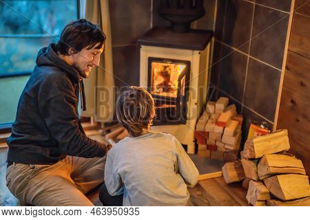 Dad And Son Spend Time By The Fireplace In Glamping. Rest In The Mountains In Glamping. Cozy Firepla