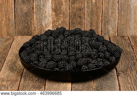 Fresh Blackberry In Plactic Bowl, Isolated On Dark Wood Background. High Resolution Photo. Full Dept