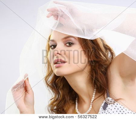 A fashionable woman standing with white material