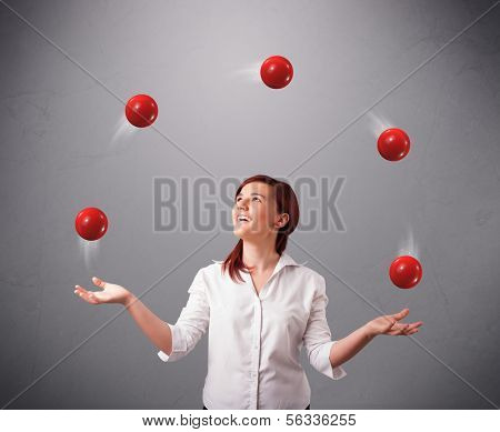 pretty young girl standing and juggling with red balls