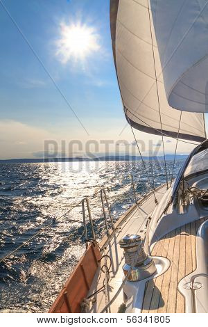 Yacht Sailing Towards Sunset On Blue Sea