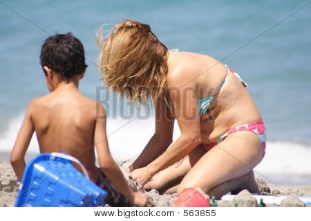 Madre e hijo jugando en la arena