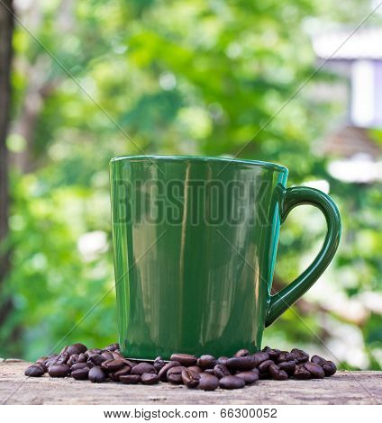 Coffee Mug And Coffee Bean On Wooden Table And Nature Background