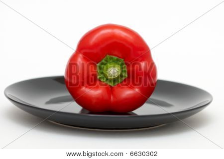 Röd paprika på en svart plåt