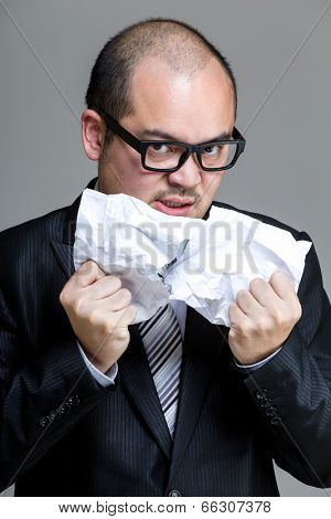 Angry business man tear paper off