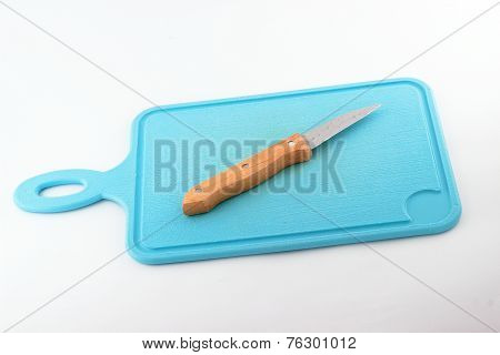 Closeup image of kitchen knife on chopping block.