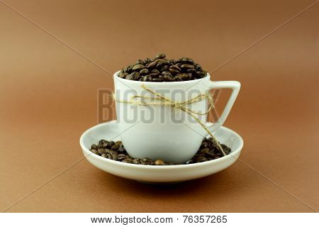 Coffee cup and saucer with a bow and coffee beans
