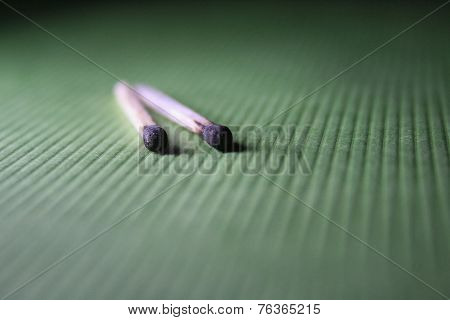 Burnt Matchstick On A Green Fabric
