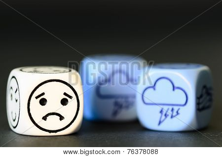 Concept Of Sad Storm Weather - Emoticon And Weather Dice On Black Background