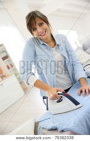 Young home service woman ironing laundry