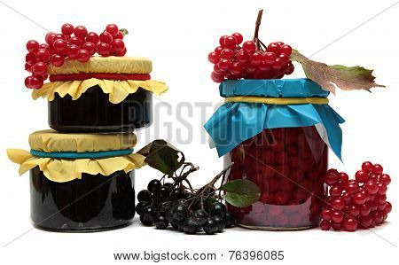 Jars of jam and berries isolated on white background.