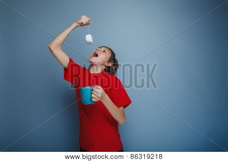 boy teenager European appearance in a red shirt holding a cup of