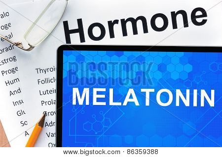 Papers with hormones list and tablet  with words melatonin.