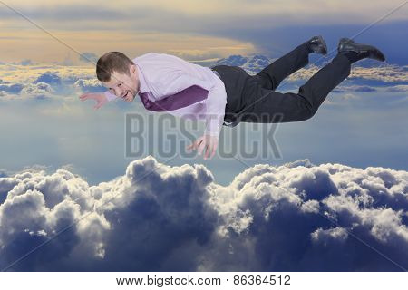 Businessman falling down over clouds in background
