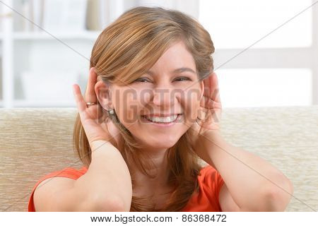 Young, smiling woman wearing deaf aid