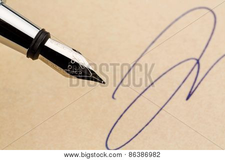 a signature and a fountain pen on yellow paper. symbolic photo for contract, testament and graphology