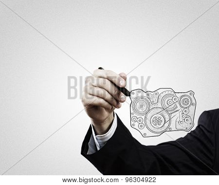 Close up of hand darwing gear mechanism with marker