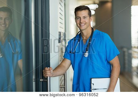 portrait of handsome doctor opening his office door