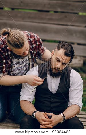 two bearded men shave