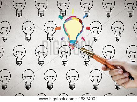 Close up of hand darwing light bulb with marker