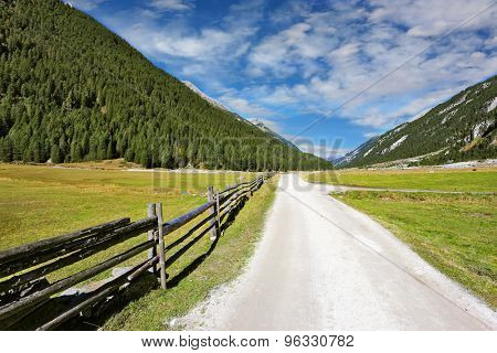Headwaters National Park Krimml. Rural idyll. Farm fields separated from the dirt road a low fence made ÃÂ¢??ÃÂ¢??of logs.