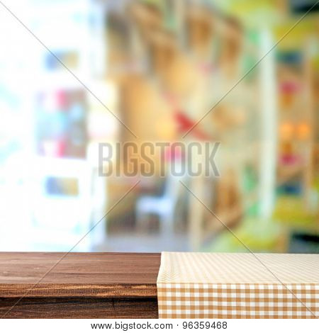 Empty wooden table with napkin on light background