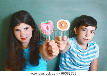 siblings  with fruit  marsh mellow candies on stick