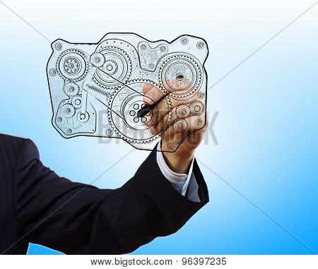 Close up of hand darwing gear mechanism with marker