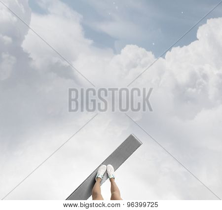 Woman standing on the edge of wooden board