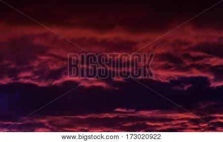 the storm sky with various shades of red and violet color with dark clouds