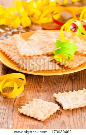 Carnival pastry with confetti on wooden table.