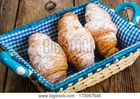 Delicious crispy croissants in bread basket. Studio Photo