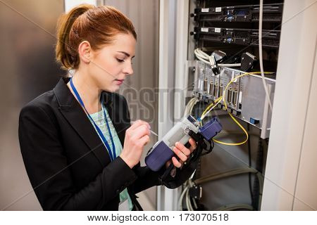 Technician using digital cable analyzer in server room