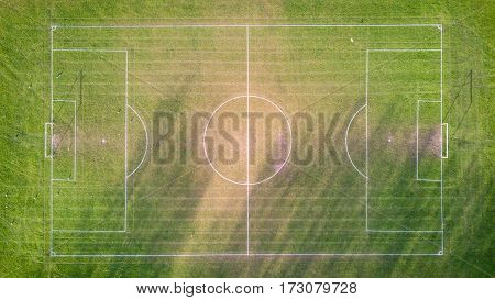 Football pitch, aerial view. Aerial drone photo looking down vertically onto an empty football (soccer) pitch with shadows cast by the low sun.