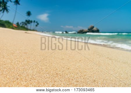 Sunny beach near Koggala - Sri Lanka The area famous for its distinct stilt fishermen, who erect a single pole in the chest-deep water on the beach, just few meters off-shore. Splittoned, vivid image.