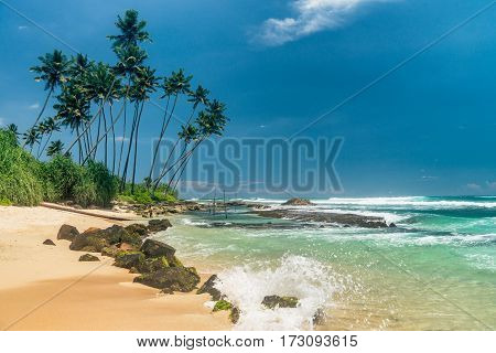 Sunny beach near Koggala - Sri Lanka The area famous for its distinct stilt fishermen, who erect a single pole in the chest-deep water on the beach, just few meters off-shore. Splittoned, vivid image.