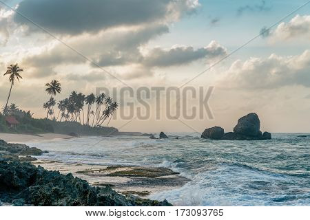 Sunny beach near Koggala - Sri Lanka The area famous for its distinct stilt fishermen, who erect a single pole in the chest-deep water on the beach, just few meters off-shore. Splittoned, vivid image.