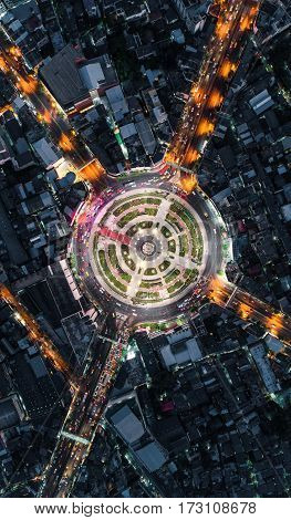 Road roundabout with car lots Wongwian Yai in BangkokThailand. street large beautiful downtown at night light. Aerial view Top view cityscape Rush hour traffic jam