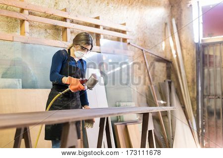 Woman Painting Table In A Woodshop