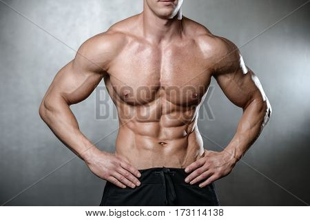 Brutal Strong Bodybuilder Man Posing In Studio On Grey Background