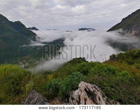 Tropical landscape with mountains hills and a valley covered in fog