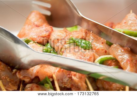 Raw marineted chicken on skewers for kebabs .
