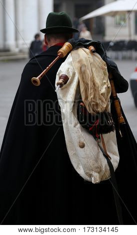 Bagpiper With A Black Cape And The Bagpipes On The Shoulders