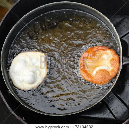 Fried Pancakes In A Pan Of Hot Oil In A Street Food Stand