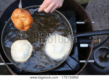 Hands Of Cook Frying Big Pancakes In A Pan Of Hot Oil In A Stree