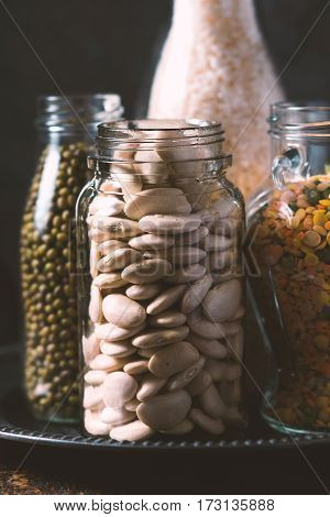 Rice, lentils, white beans in bottles side view vertical
