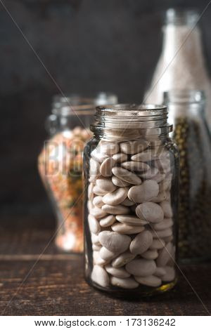 Bank with white beans, lentils on the table vertical
