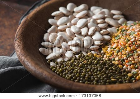 Placer green and white beans in a wooden bowl closeup horizontal