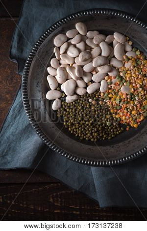 Tin plate with beans on gray napkin vertical