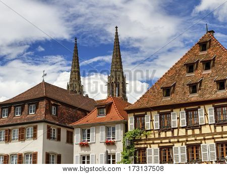 Saints-Pierre-et-Paul church towers and half-timberedr houses by day, Obernai, France